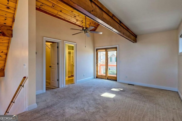 unfurnished room with carpet floors, visible vents, beamed ceiling, and baseboards