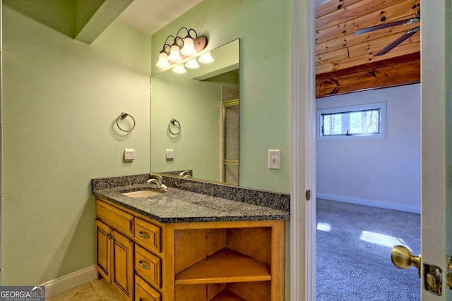 bathroom featuring an enclosed shower, baseboards, and vanity