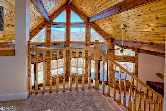 interior space with wood ceiling, beamed ceiling, carpet flooring, high vaulted ceiling, and a mountain view