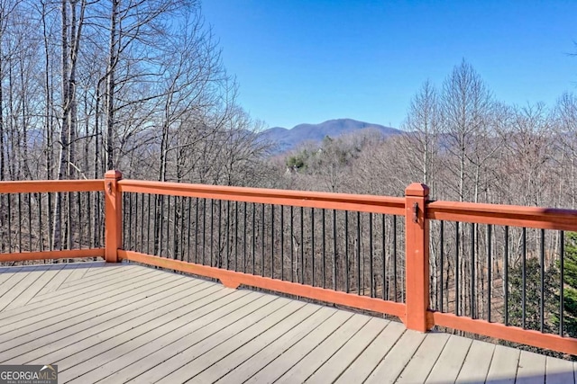 wooden terrace with a mountain view and a view of trees