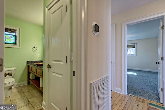 bathroom featuring baseboards, visible vents, vanity, and toilet