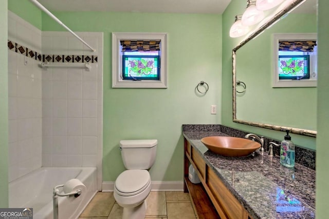 bathroom with toilet, bathing tub / shower combination, baseboards, vanity, and tile patterned floors