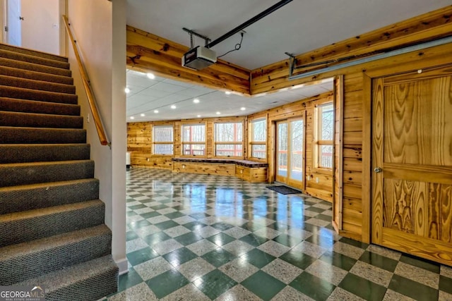 foyer entrance with wooden walls, stairs, and recessed lighting