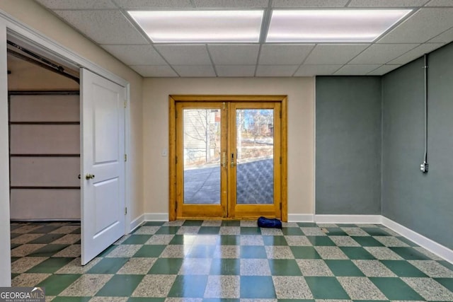 entryway with baseboards, french doors, a drop ceiling, and tile patterned floors