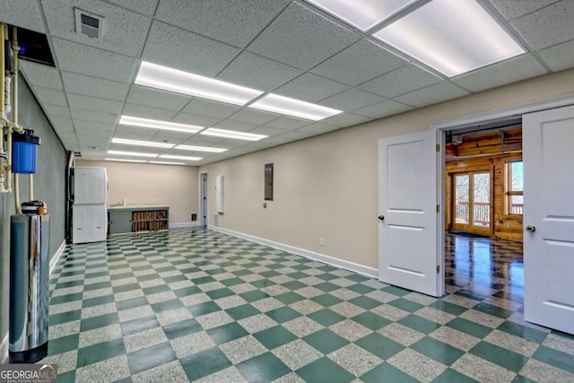 below grade area with freestanding refrigerator, a paneled ceiling, visible vents, and baseboards