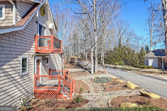 exterior space featuring aphalt driveway and a balcony