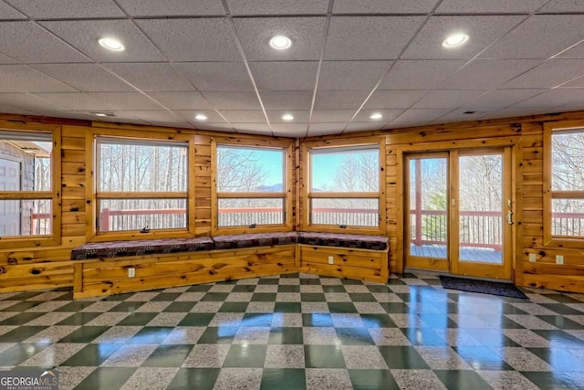 interior space with a paneled ceiling, wood walls, and recessed lighting