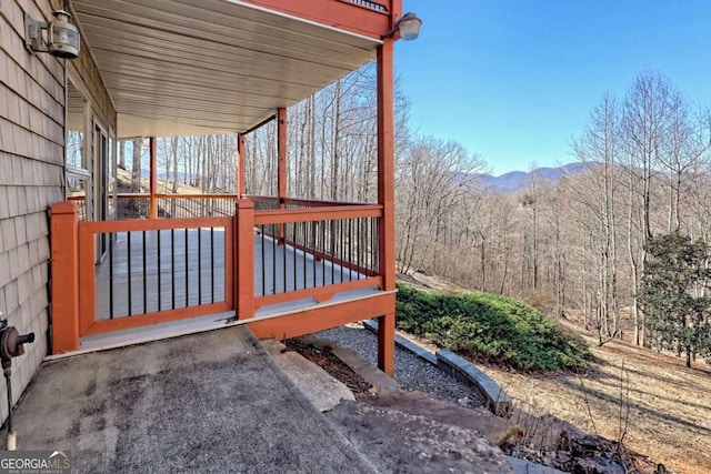 deck featuring a mountain view and a wooded view