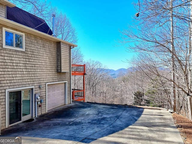 view of side of home featuring concrete driveway and an attached garage