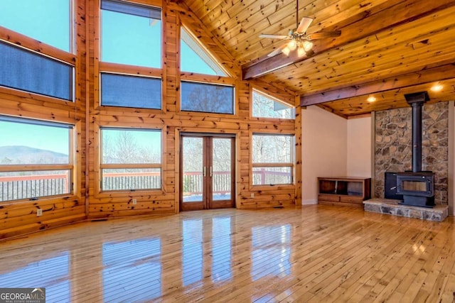 unfurnished living room featuring wood-type flooring, a wood stove, high vaulted ceiling, wooden ceiling, and beamed ceiling