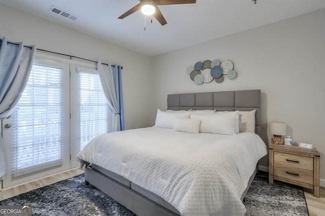 bedroom featuring light wood finished floors, visible vents, and a ceiling fan