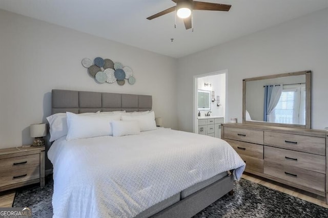 bedroom featuring connected bathroom, light wood finished floors, and ceiling fan