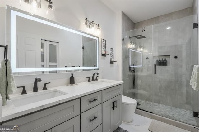 bathroom featuring double vanity, marble finish floor, a sink, and a stall shower