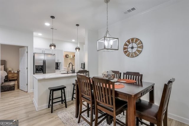 dining room with recessed lighting, baseboards, visible vents, and light wood finished floors