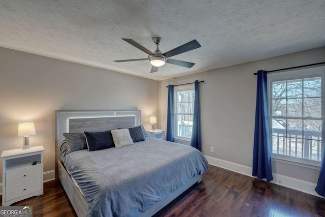 bedroom featuring a textured ceiling, ceiling fan, wood finished floors, and baseboards