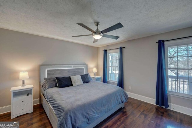 bedroom with a ceiling fan, a textured ceiling, baseboards, and wood finished floors