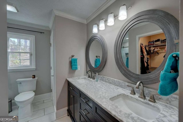 bathroom with baseboards, toilet, crown molding, a textured ceiling, and a sink