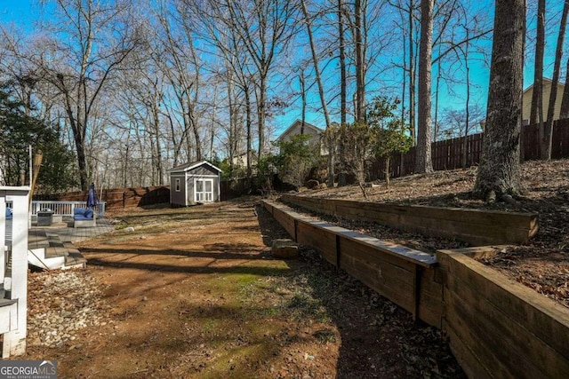 view of yard with a storage unit, an outdoor structure, and a fenced backyard