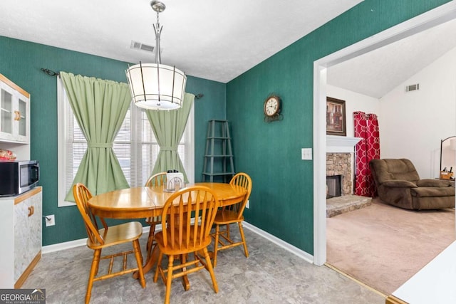 1800 Rockdale Cir, Snellville, GA 30078 - carpeted dining room featuring baseboards, visible vents, and a stone fireplace