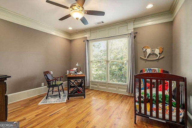 bedroom with light wood finished floors, baseboards, visible vents, and ornamental molding