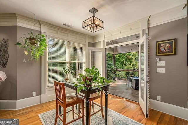 dining space featuring light wood-type flooring, visible vents, and baseboards