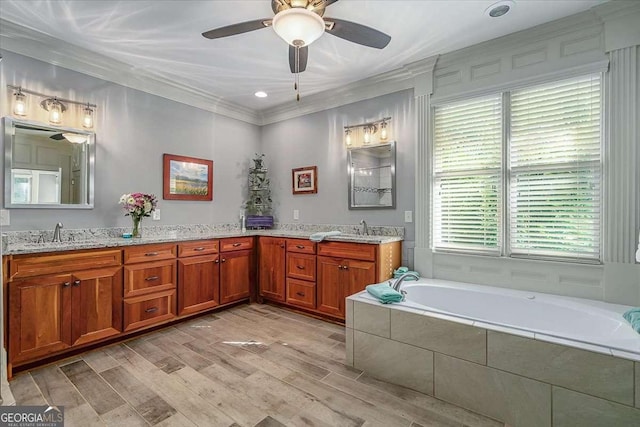 full bathroom with double vanity, ornamental molding, a sink, and wood finished floors