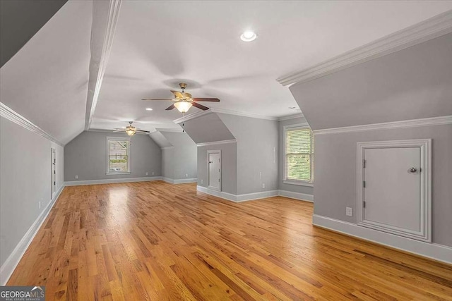 bonus room with light wood-type flooring, vaulted ceiling, baseboards, and ceiling fan