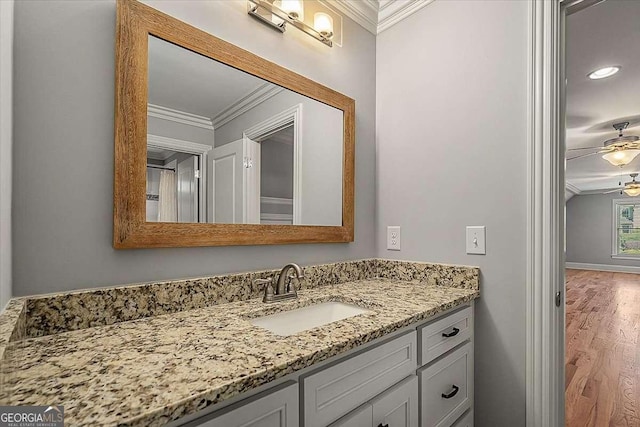 bathroom with ceiling fan, wood finished floors, vanity, and crown molding