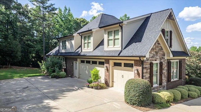 view of front facade with driveway, a shingled roof, stone siding, an attached garage, and board and batten siding