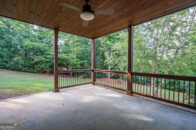 view of patio / terrace featuring a view of trees and a ceiling fan