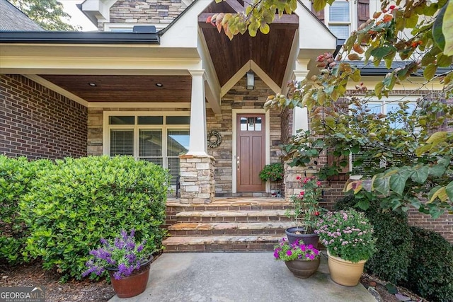 doorway to property with stone siding and brick siding