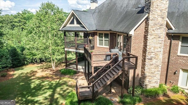 exterior space with brick siding, a chimney, stairway, a sunroom, and a deck