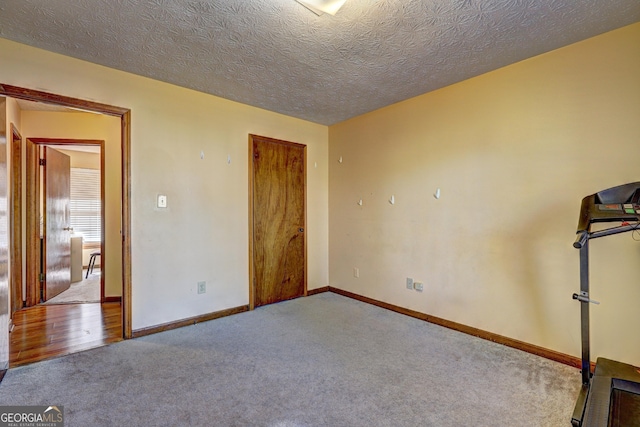 unfurnished bedroom with a closet, carpet flooring, a textured ceiling, and baseboards