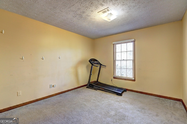 workout area with carpet floors, visible vents, a textured ceiling, and baseboards