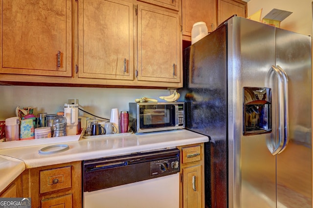 kitchen with white dishwasher, a toaster, light countertops, brown cabinets, and stainless steel fridge