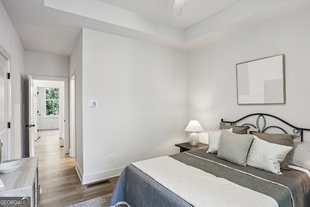 bedroom featuring visible vents, baseboards, and wood finished floors