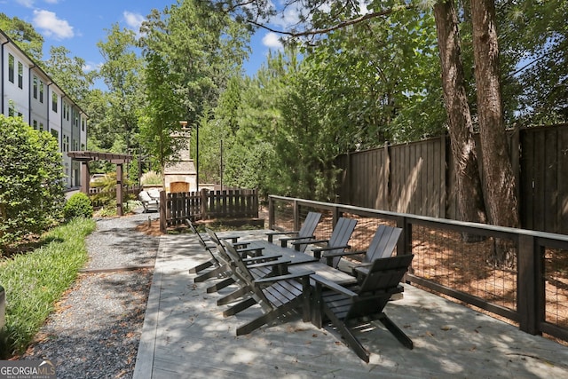 view of patio / terrace with an outdoor stone fireplace and fence