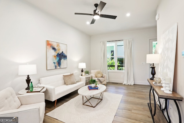 living area featuring baseboards, ceiling fan, light wood-style flooring, and recessed lighting