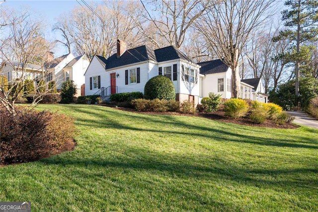 view of front of home featuring a chimney and a front yard