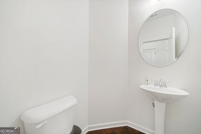 bathroom with wood finished floors, toilet, and baseboards