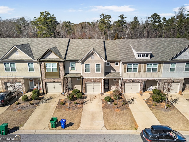 view of property featuring board and batten siding, driveway, and a garage