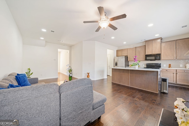 kitchen featuring dark wood-style floors, open floor plan, a center island, light countertops, and black appliances