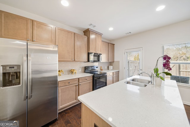 kitchen featuring black / electric stove, a sink, visible vents, backsplash, and stainless steel fridge