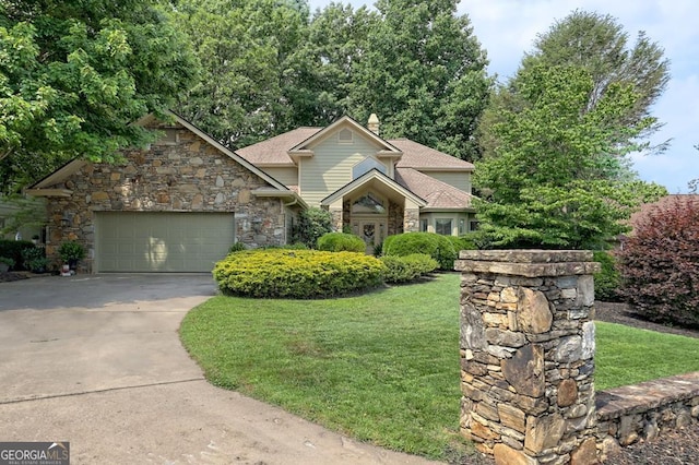 view of front of property with concrete driveway, stone siding, a chimney, an attached garage, and a front yard