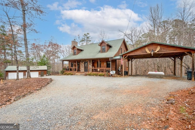 view of front of home with an outbuilding, driveway, a porch, and a chimney