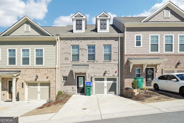 townhome / multi-family property featuring a garage, driveway, and brick siding