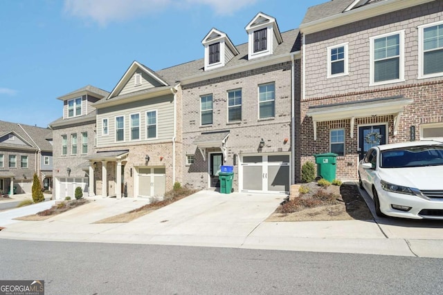 multi unit property with concrete driveway, brick siding, and an attached garage