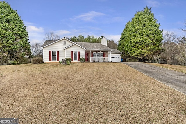 ranch-style home featuring a chimney, covered porch, a front yard, a garage, and driveway