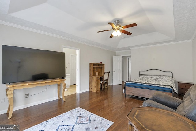 bedroom featuring a raised ceiling, ornamental molding, ceiling fan, wood finished floors, and baseboards