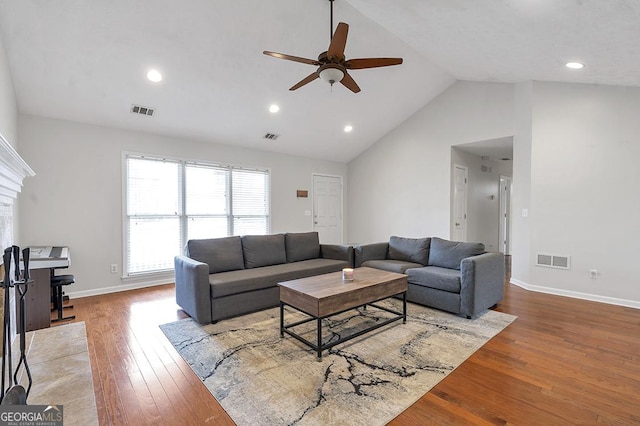 living room with high vaulted ceiling, baseboards, visible vents, and hardwood / wood-style floors